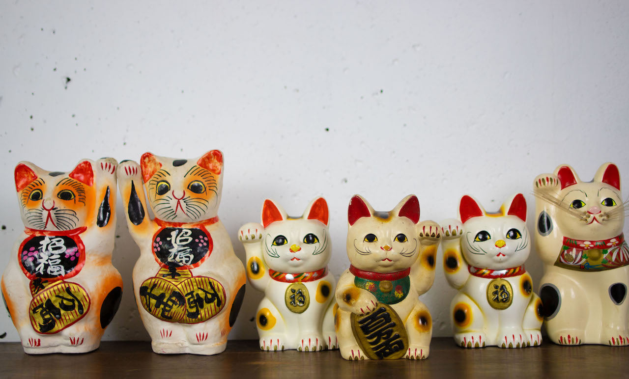 Open-bottomed bearded beckoning cat piggy bank.