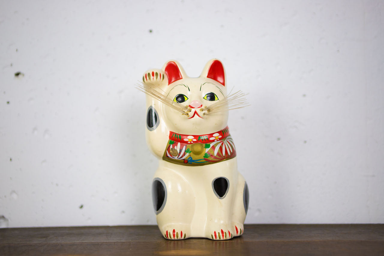 Open-bottomed bearded beckoning cat piggy bank.