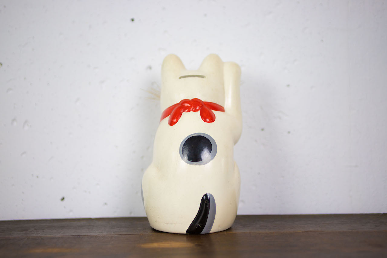 Open-bottomed bearded beckoning cat piggy bank.