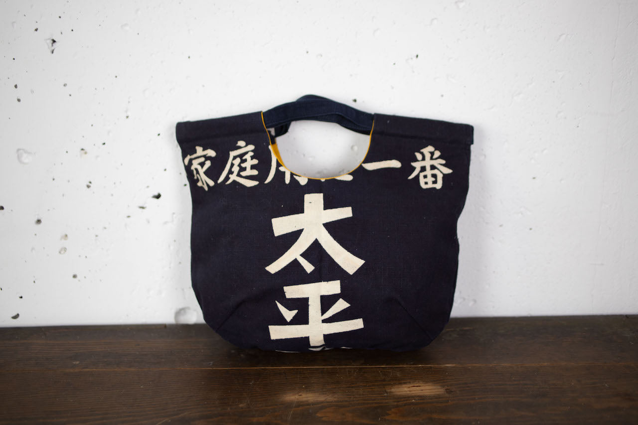 Uniquely shaped handbag made of hand-stitched indigo-dyed fabric.