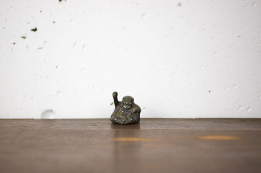 Unique little Daruma model figurine with raised arms.