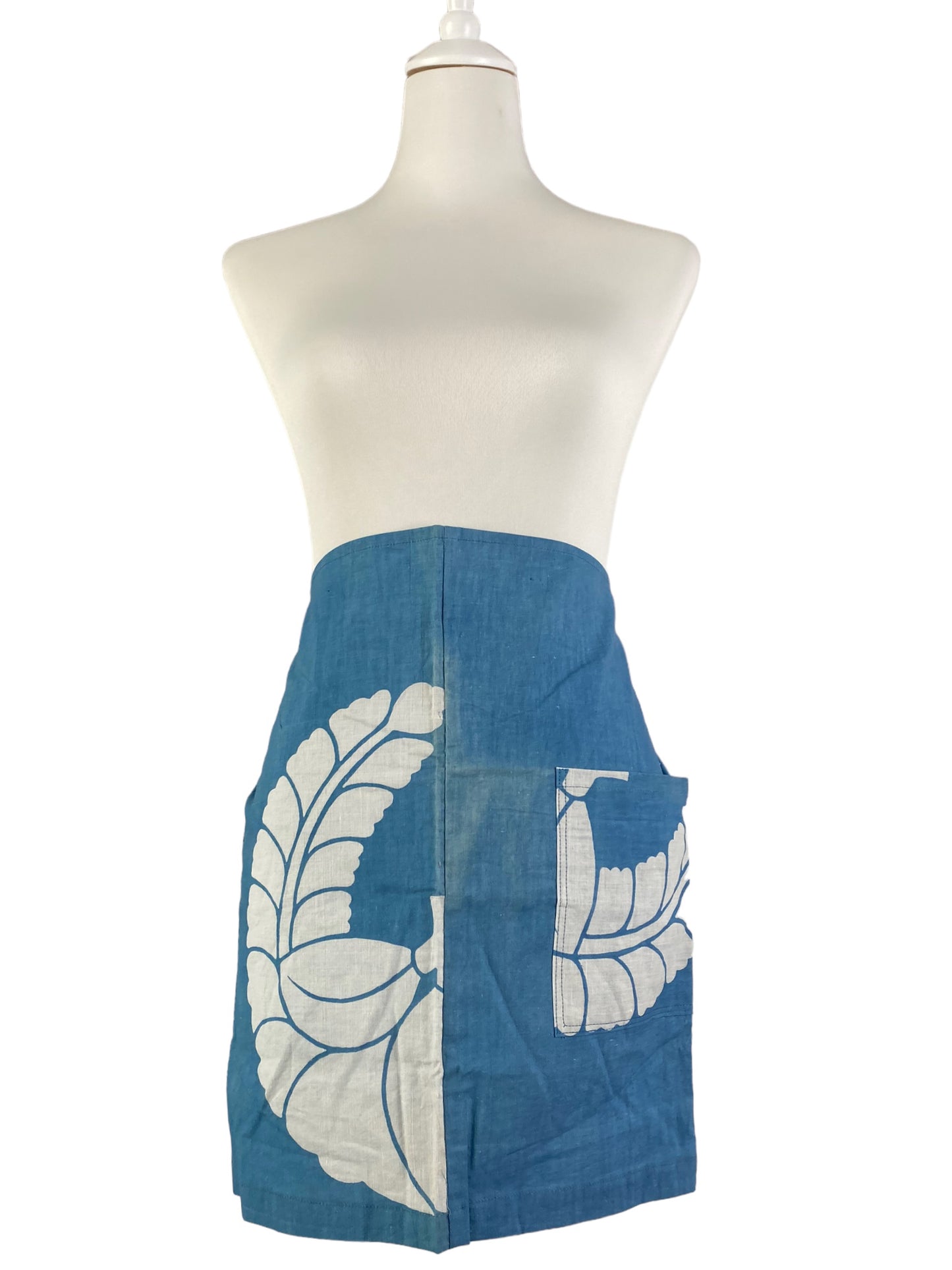 Blue indigo apron with a family crest pattern.
